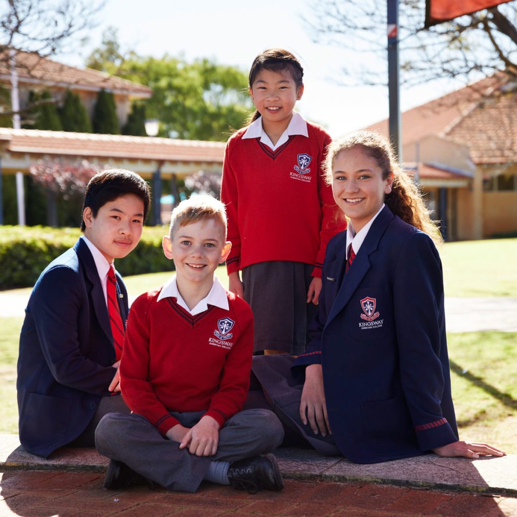 Primary School students and Secondary School students sitting outdoors together